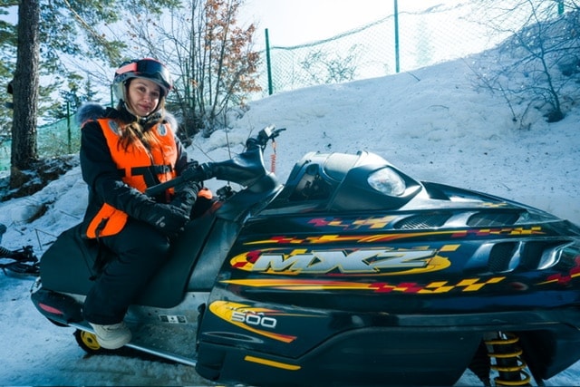 Snowmobiles under aurora sky